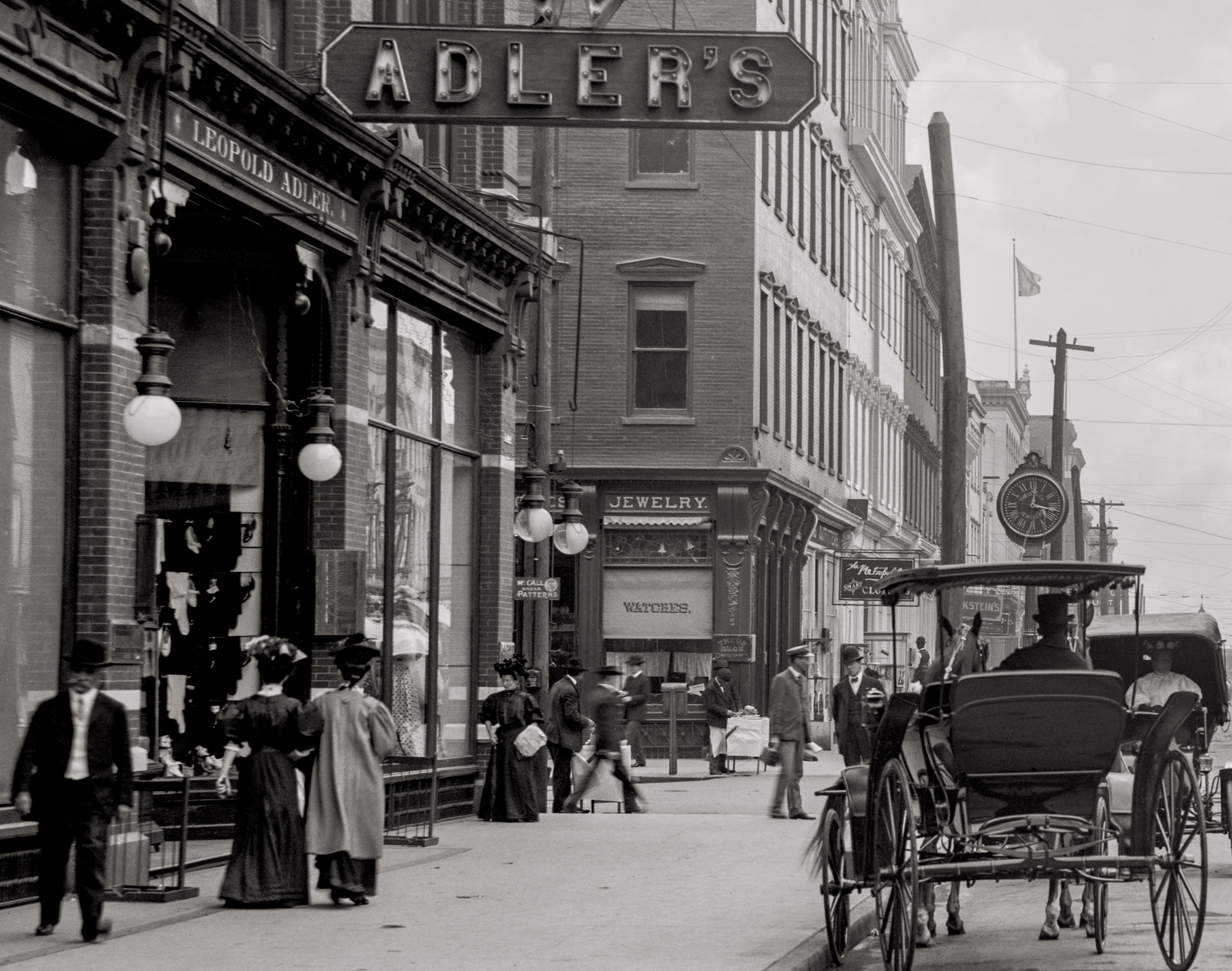 A closeup of Adler's store with women walking by.