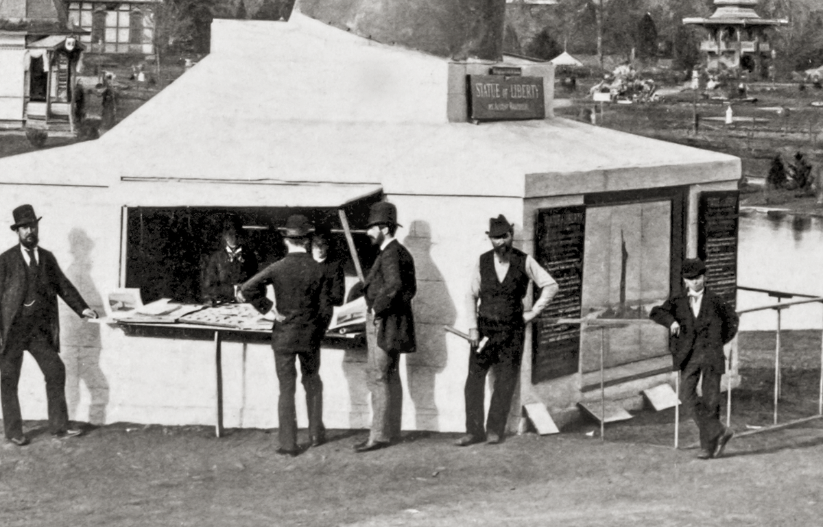 Men at the bottom of the flame in a tent buying tickets to go up to the top of the flame.